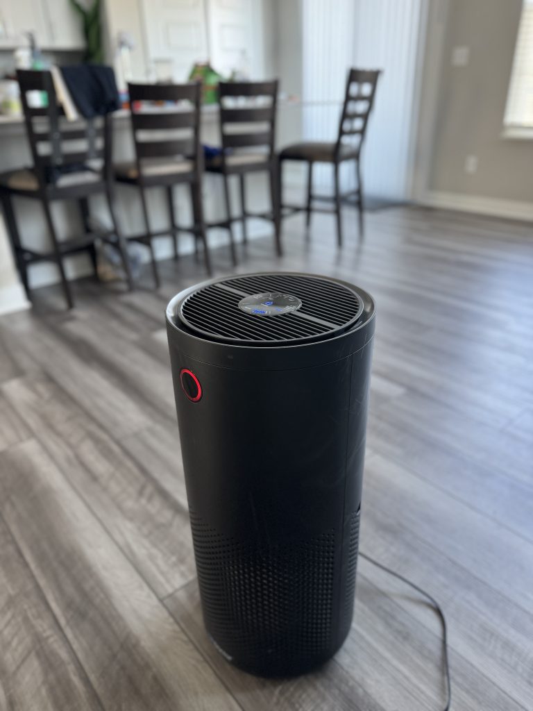 AirDoctor 4000 air purifier placed in my kitchen area showing the red air quality indicator light.