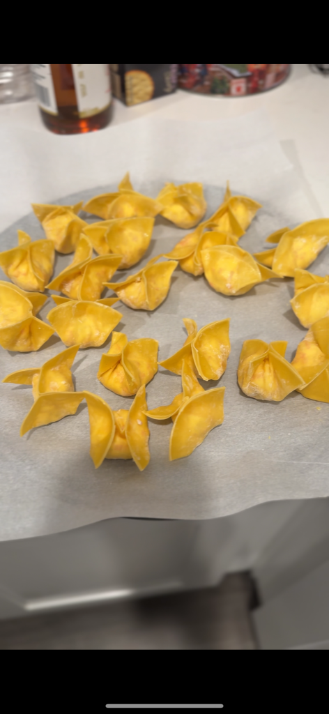 Freshly assembled Crab Rangoons filled with classic cream cheese and crab mixture, sealed and ready for frying. Perfect homemade Chinese takeout style appetizer.