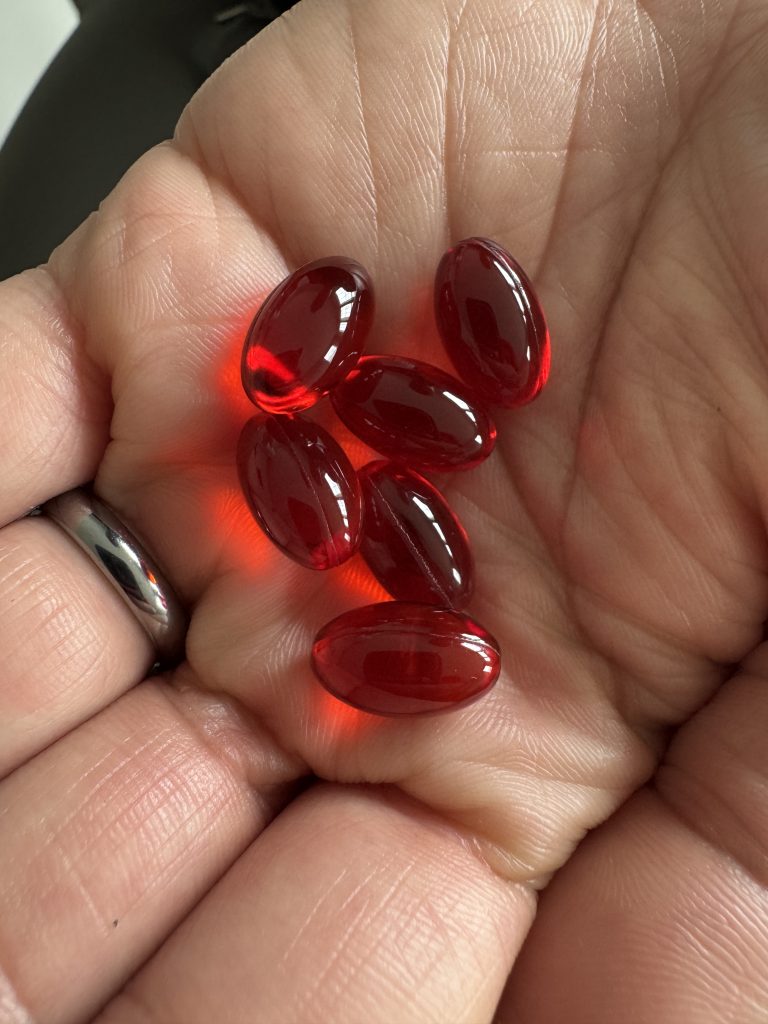 Red krill oil softgel capsules showing natural astaxanthin color