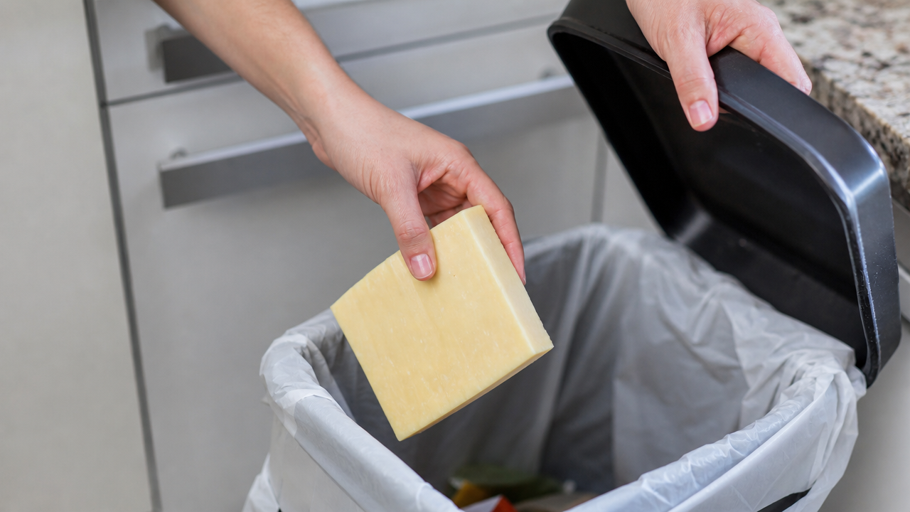 A person discarding a block of raw milk cheese into the trash following the nationwide recall